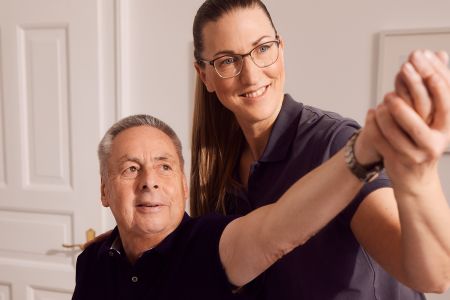 Patient macht Krankengymnastik auf neurophysiologischer Grundlage mit Physiotherapeutin