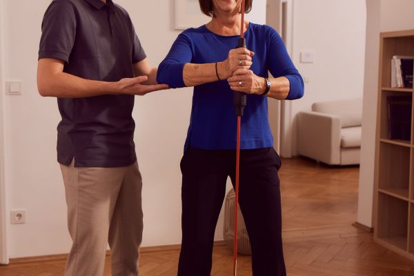 Personal Trainer und Patientin haben viel Spaß beim Fitness-Training zu Hause