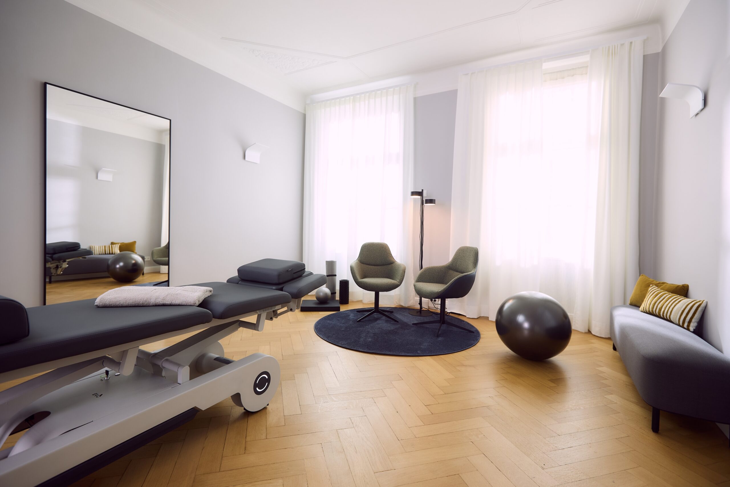 Behandlungsraum einer Privatpraxis für Physiotherapie mit hochwertiger und beheizbarer Behandlungsliege und weiteren Utensilien für eine physiotherapeutische Behandlung.