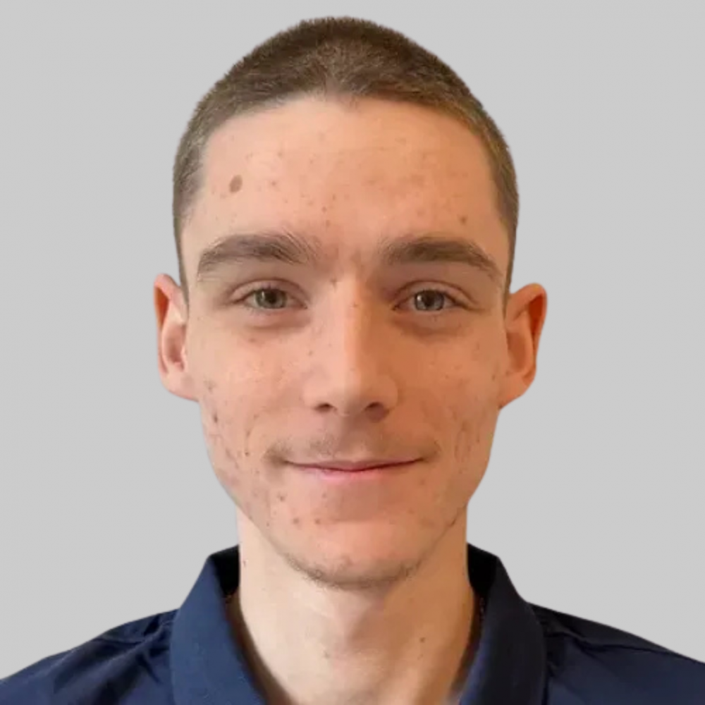 Eine Person blickt freundlich in die Kamera, weißer Hintergrund.