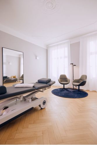 Behandlungsraum einer Privatpraxis für Physiotherapie mit hochwertiger und beheizbarer Behandlungsliege und weiteren Utensilien für eine physiotherapeutische Behandlung.