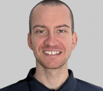 Ein lächelnder Mann trägt ein dunkelblaues Hemd.