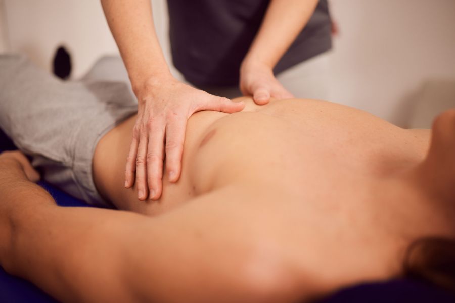 Massage eines Oberkörpers bei einem Physiotherapie Hausbesuch